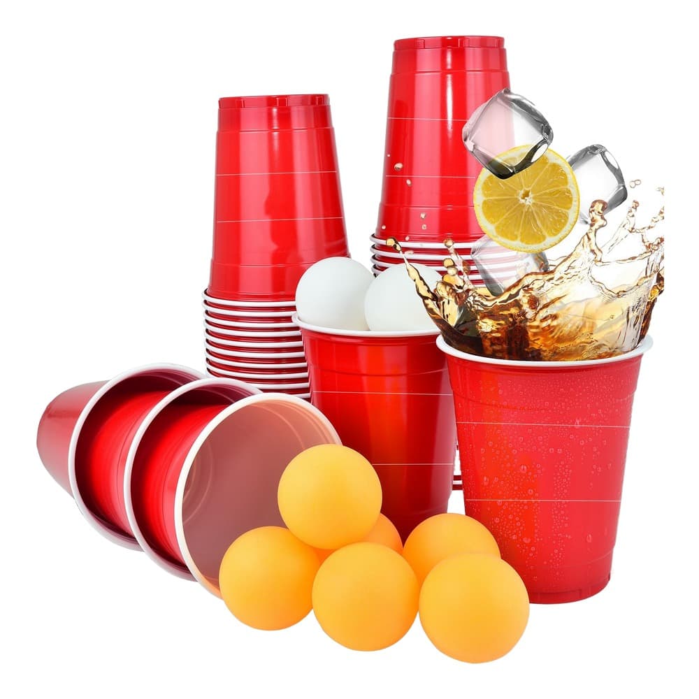 Collection of red plastic cups, yellow balls, and beverage accessories arranged on white background with lemon slice and drink splash.