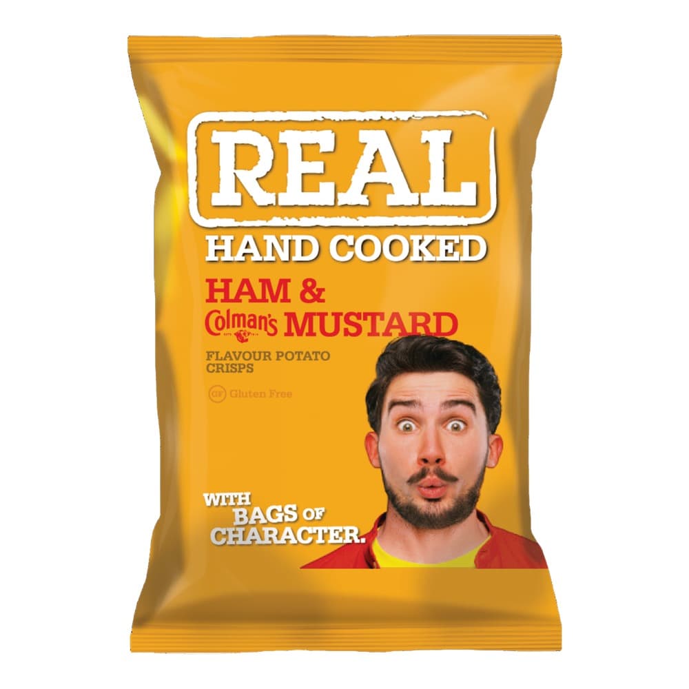 A golden yellow packet of REAL brand hand cooked ham and Colmans mustard flavour potato crisps with a surprised man's face on the packaging against a solid yellow background.