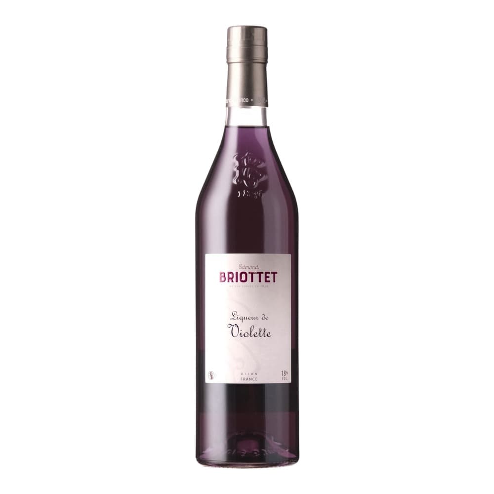 A bottle of Edmond Briottet Liqueur de Violette with dark purple liquid, silver cap, and white label on a plain white background.