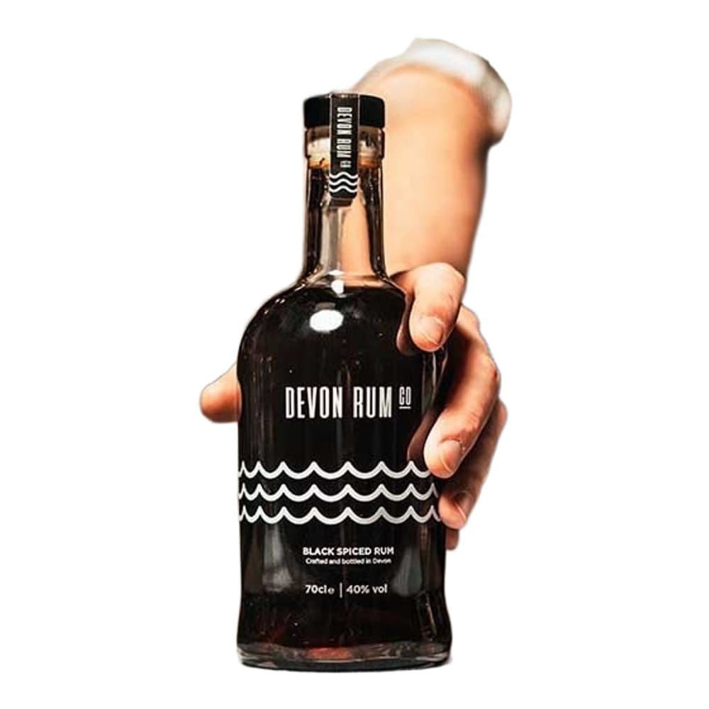 Person in striped shirt holding a bottle of Devon Rum Co Black Spiced Rum against a blurred bar background