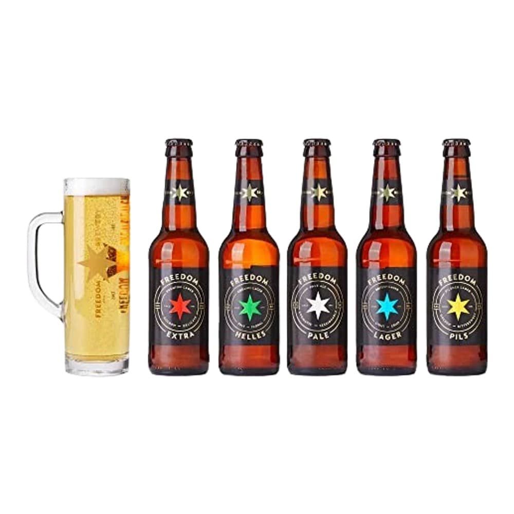 Five Freedom Brewery beer bottles with different coloured labels arranged next to a full pint glass of golden lager on a white background.