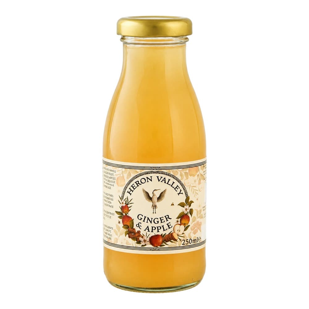 A glass bottle of Heron Valley Ginger & Apple juice with a golden cap against a white background.