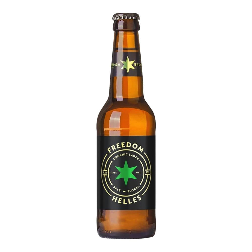 A brown glass bottle of Freedom Helles organic lager beer with a black label featuring a green star design, displayed against a white background.