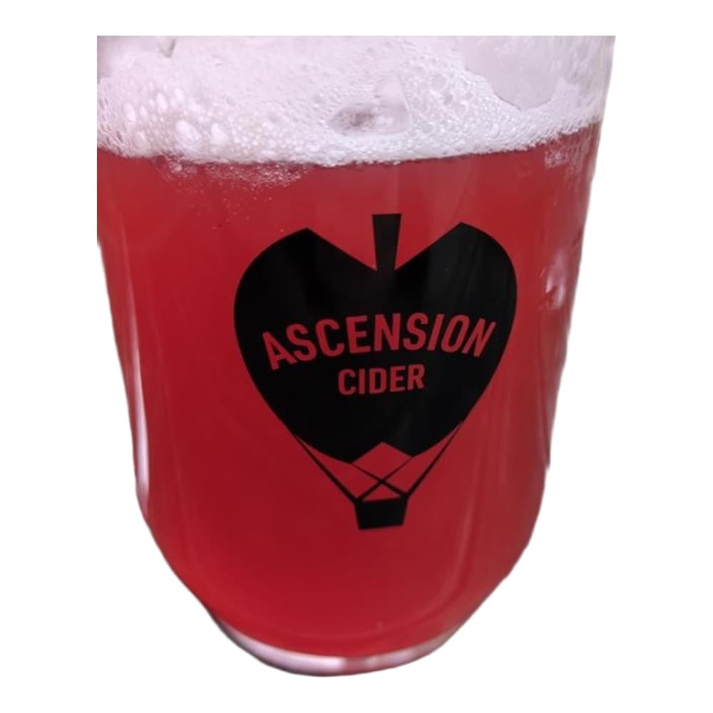 A glass of red cider from Ascension Cider brewery with a white foam head, photographed outdoors on a wooden table.