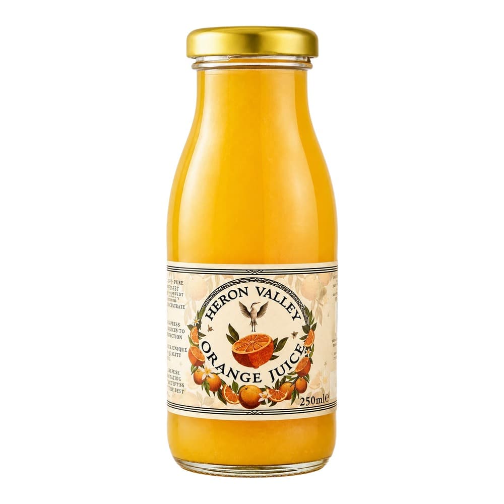 A glass bottle of Heron Valley orange juice with a gold cap, displayed against a white background. The label features an illustration of oranges and a heron.