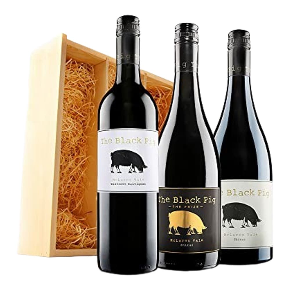 Three bottles of The Black Pig wine displayed with a wooden gift box lined with straw on a white background.