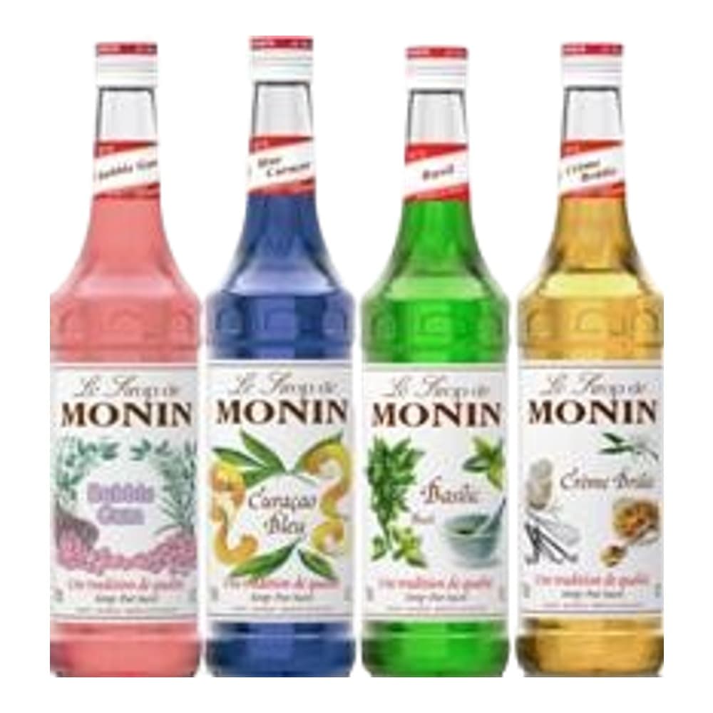 Four Monin brand flavoured syrup bottles in red, blue, green, and golden amber colours arranged in a row against a white background.