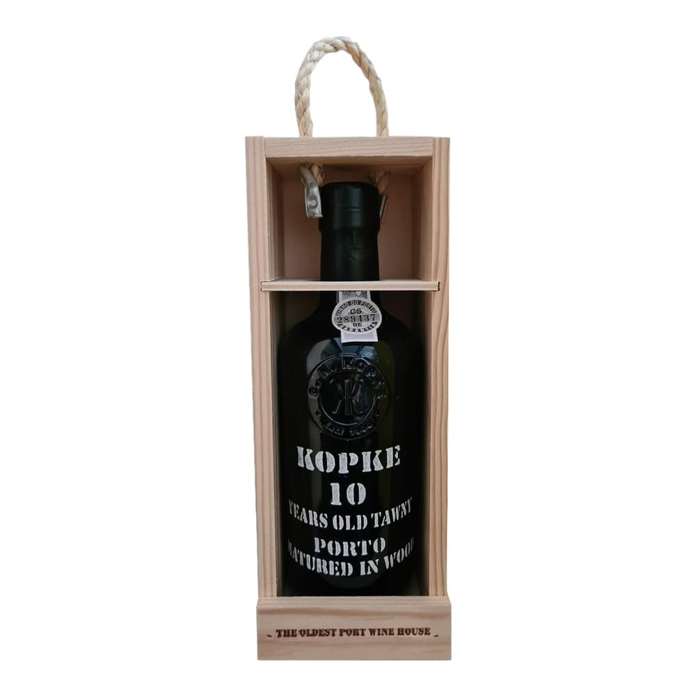 A bottle of Kopke 10 Years Old Tawny Porto wine displayed in a light wooden presentation box with rope handles and an informational label at the bottom.