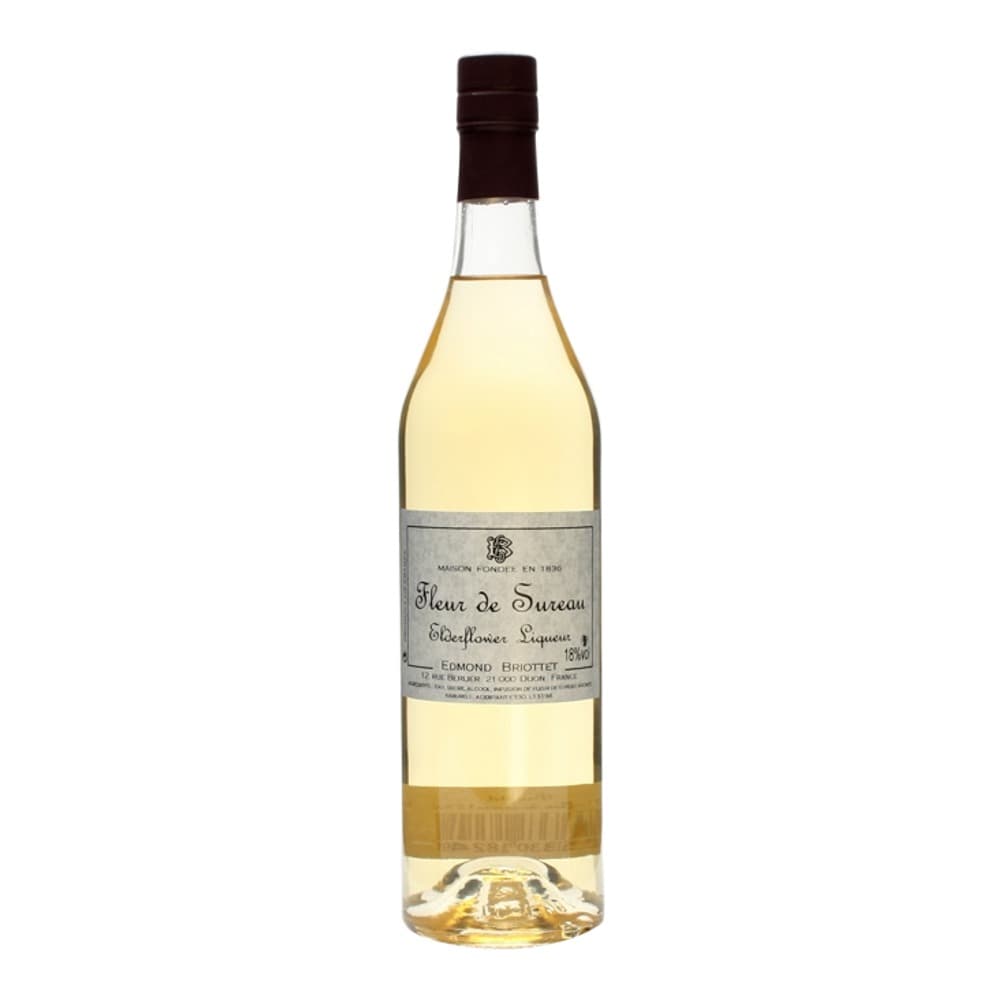 A bottle of Fleur de Sureau elderflower liqueur with a dark brown cap, pale yellow liquid, and grey label on a white background.