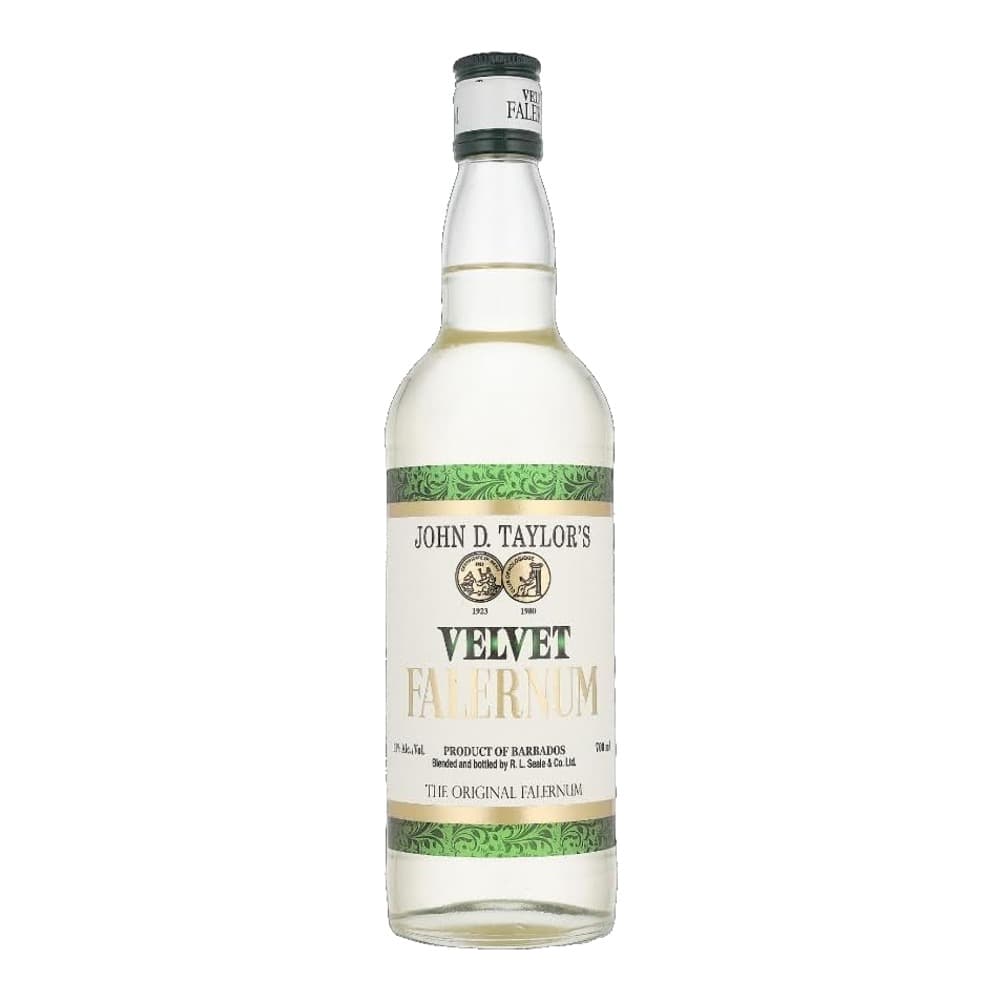 A clear glass bottle of John D. Taylor's Velvet Falernum liqueur with a black cap and green ornamental label bands, displayed against a white background.
