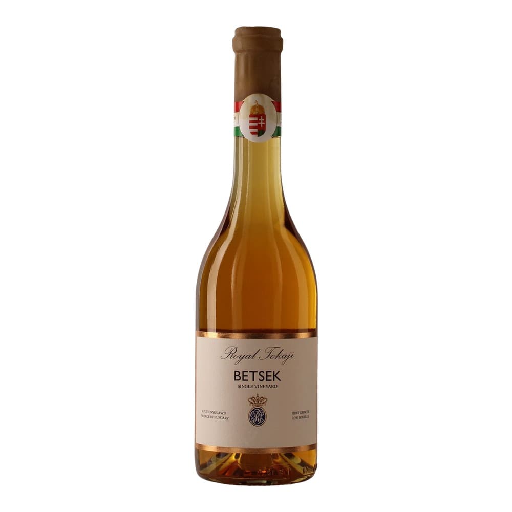 A bottle of Royal Tokaji Betsek single vineyard wine with golden-amber liquid, cork closure, and Hungarian crest label on a white background.