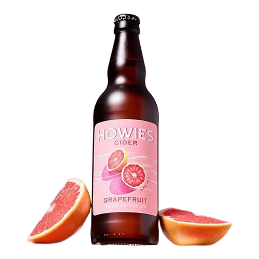 A bottle of Howes grapefruit cider on a pink and coral background, flanked by fresh grapefruit slices.