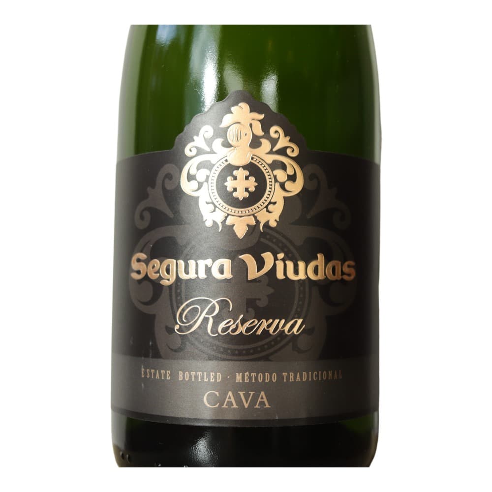 A green glass bottle of Segura Viudas Reserva Cava with ornate gold and black label featuring decorative crest and cross motif.