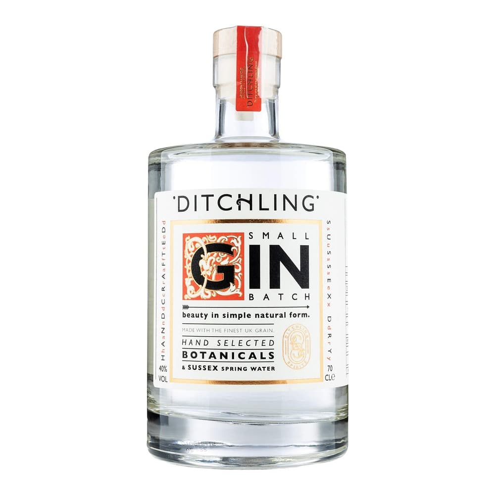 A clear glass bottle of Ditchling Small Batch Gin with a white label featuring an ornate red initial 'G', red wax seal, and product information on a plain white background.