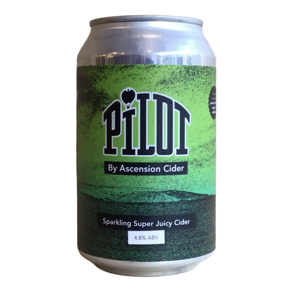 A silver aluminium can of Pilot sparkling cider by Ascension Cider on a wooden surface against a light beige wall. The can features a bright green label with black text and displays 4.8% ABV.