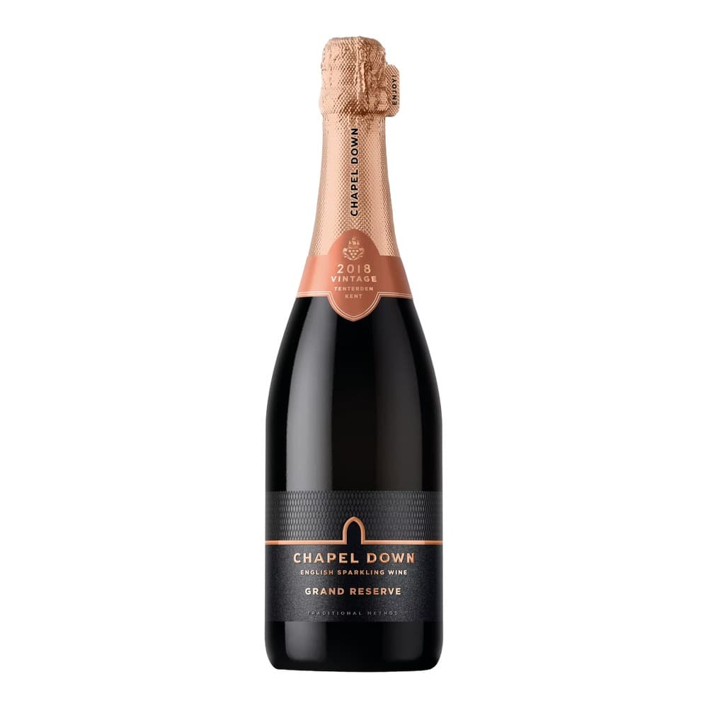 A bottle of Chapel Down Grand Reserve 2018 vintage English sparkling wine with rose-gold foil wrapping and black label on a white background.