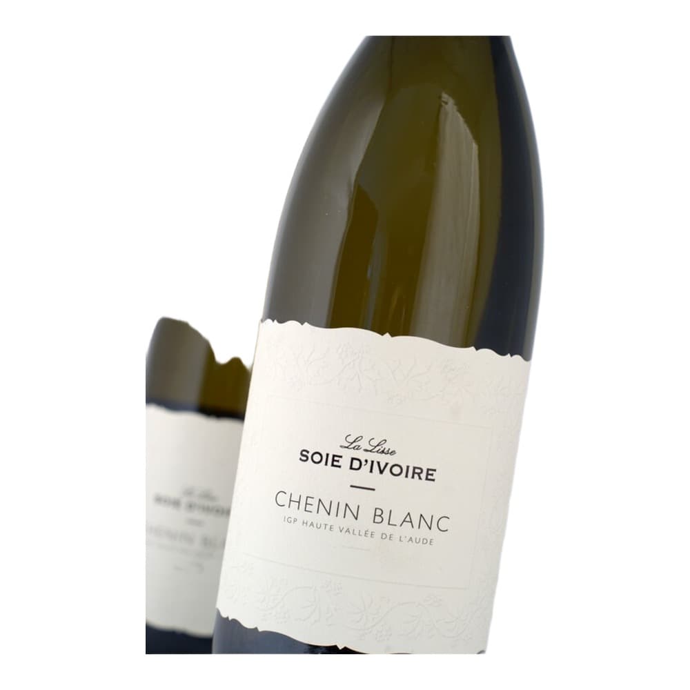 A bottle of Soie d'Ivoire Chenin Blanc white wine with a cream-coloured label on a neutral background, with additional wine bottles slightly blurred in the background.