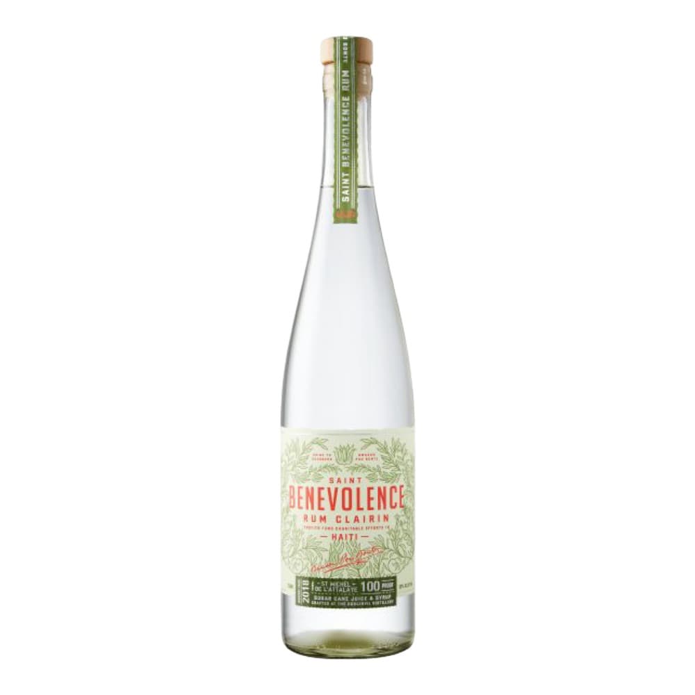 A clear glass bottle of Saint Benevolence Rum Clairin from Haiti with a pale green and cream label, featuring botanical imagery and a cork-style cap against a white background.