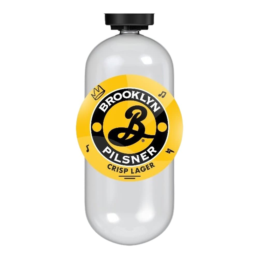 A clear glass bottle of Brooklyn Pilsner Crisp Lager beer with a distinctive yellow and black circular label featuring a stylised 'B' logo and musical notes.