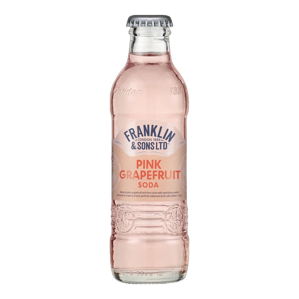 A glass bottle of Franklin & Sons pink grapefruit soda with a metal crown cap, containing pink-hued carbonated beverage, isolated on a black background.