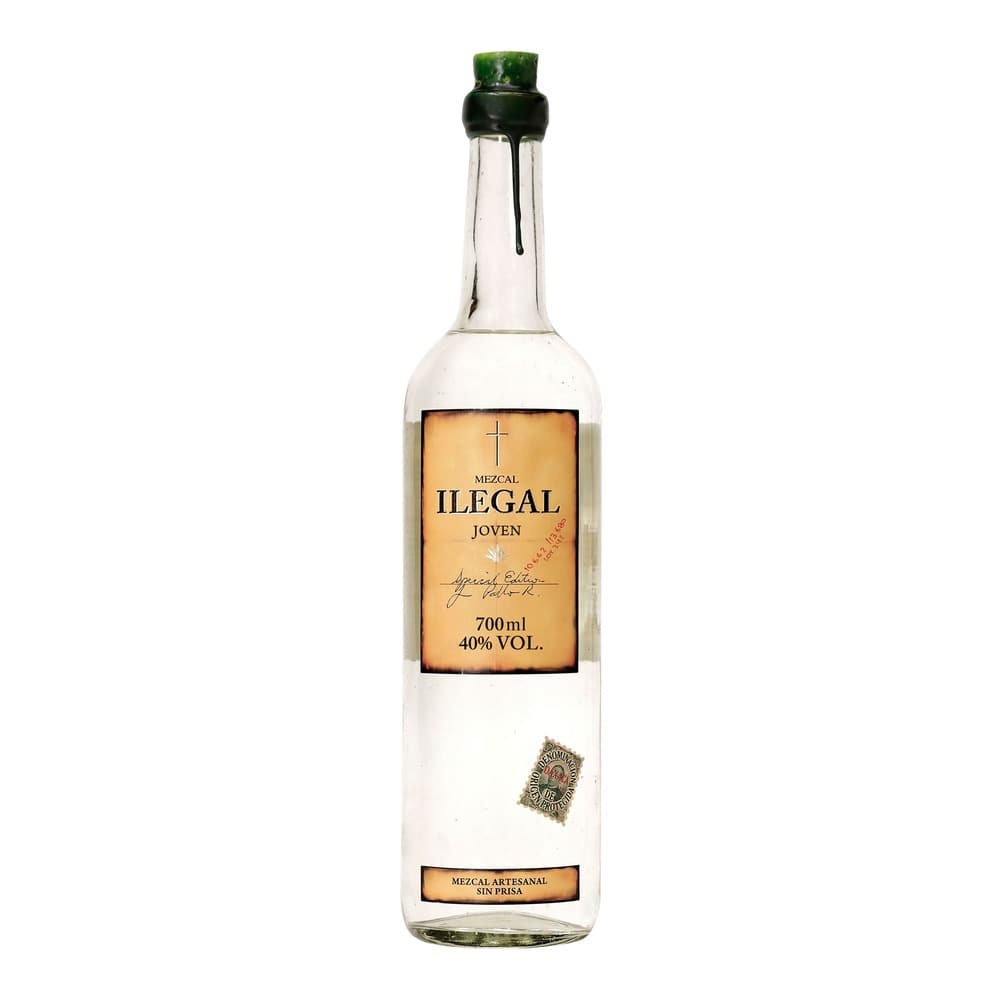 A clear glass bottle of Mezcal Ilegal Joven mezcal spirit with a tan and black label, 700ml, 40% alcohol by volume, featuring a cross symbol and artisanal certification badge against a white background.