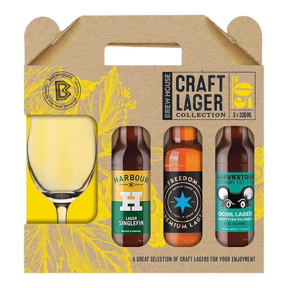 A cardboard gift box containing three 330ml craft lager bottles with a glass of pale lager displayed on the left side against a yellow wheat-patterned background.