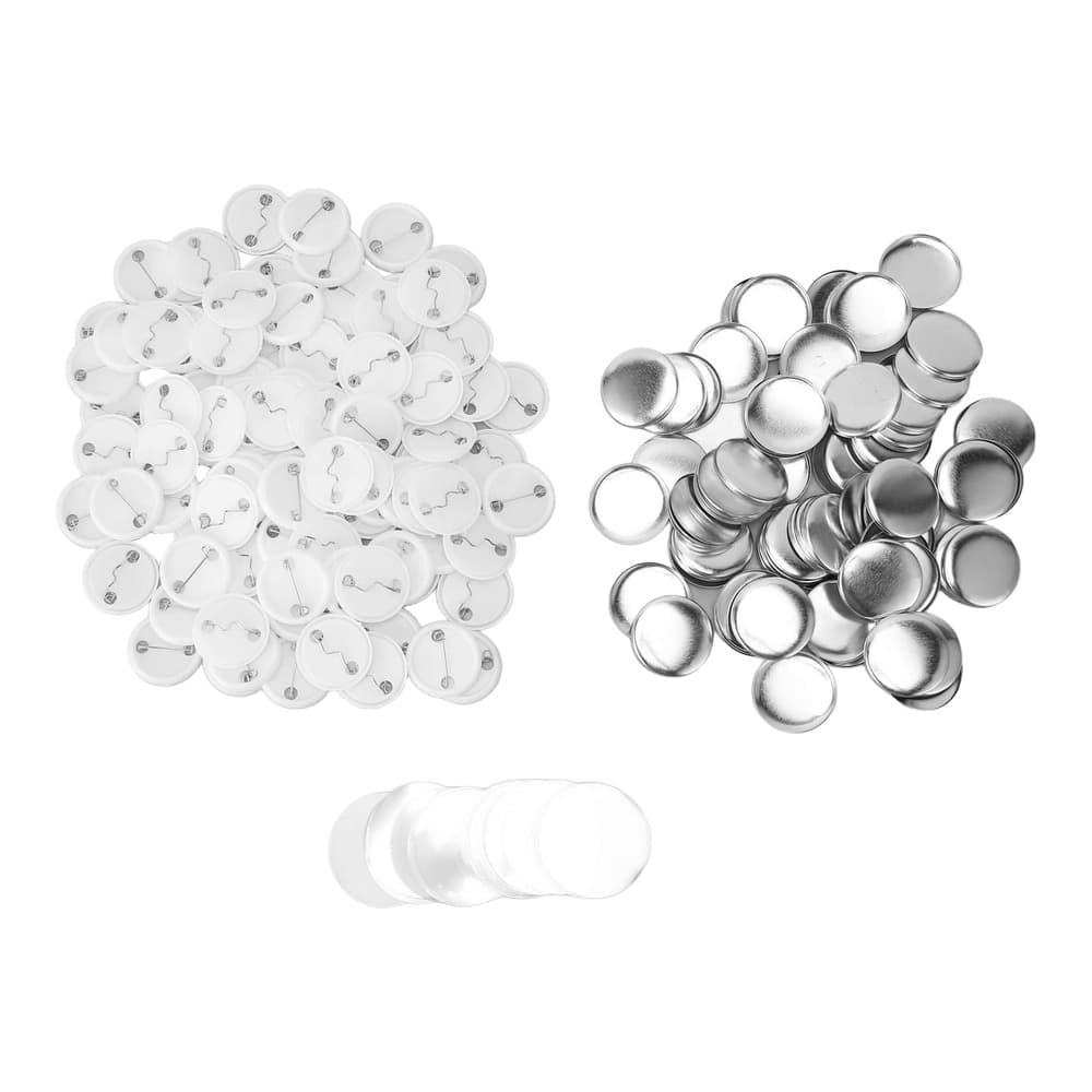 Flat lay of badge making supplies including circular pin backs with posts, metal casings with bands, and clear acrylic dome covers arranged in groups on white background