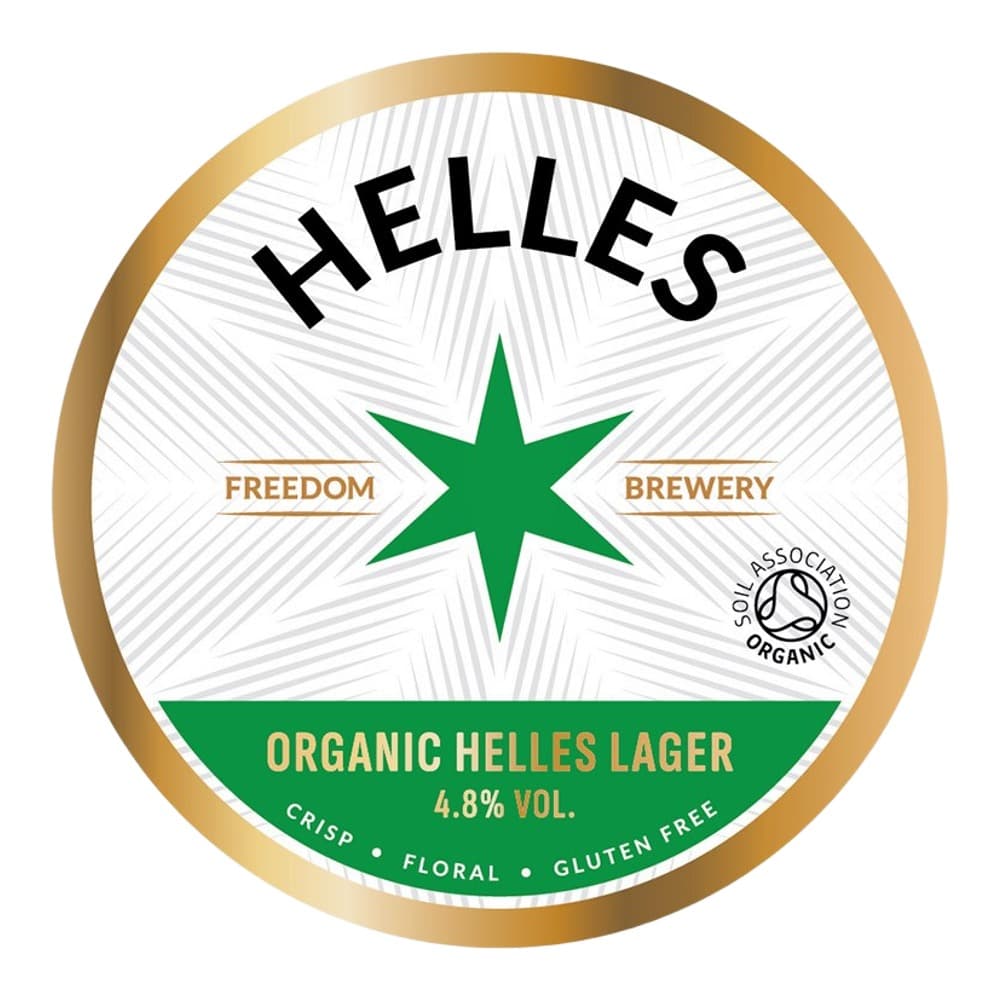 Circular beer bottle label for Helles Freedom Brewery organic lager featuring a green star, gold lettering, and Soil Association organic certification logo.