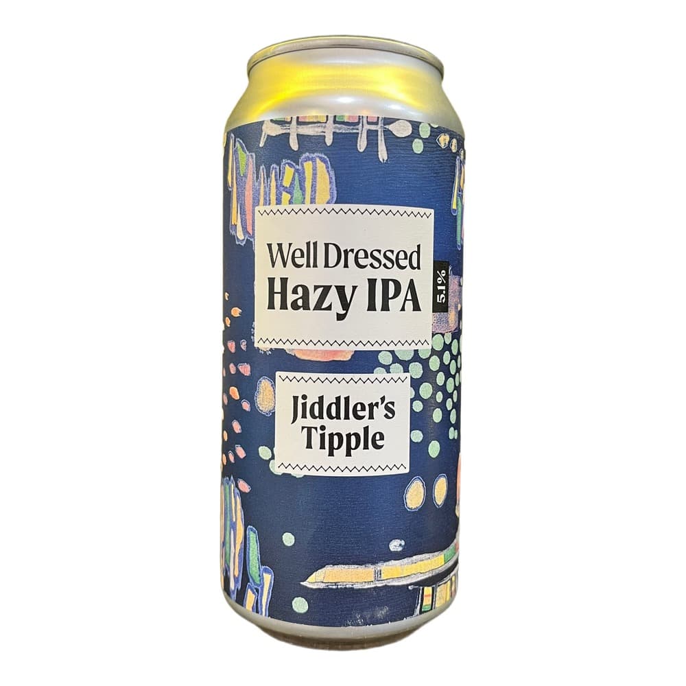 A 50cl can of Well Dressed Hazy IPA beer with blue label and colourful abstract design, displayed on a dark surface against a warm yellow background.