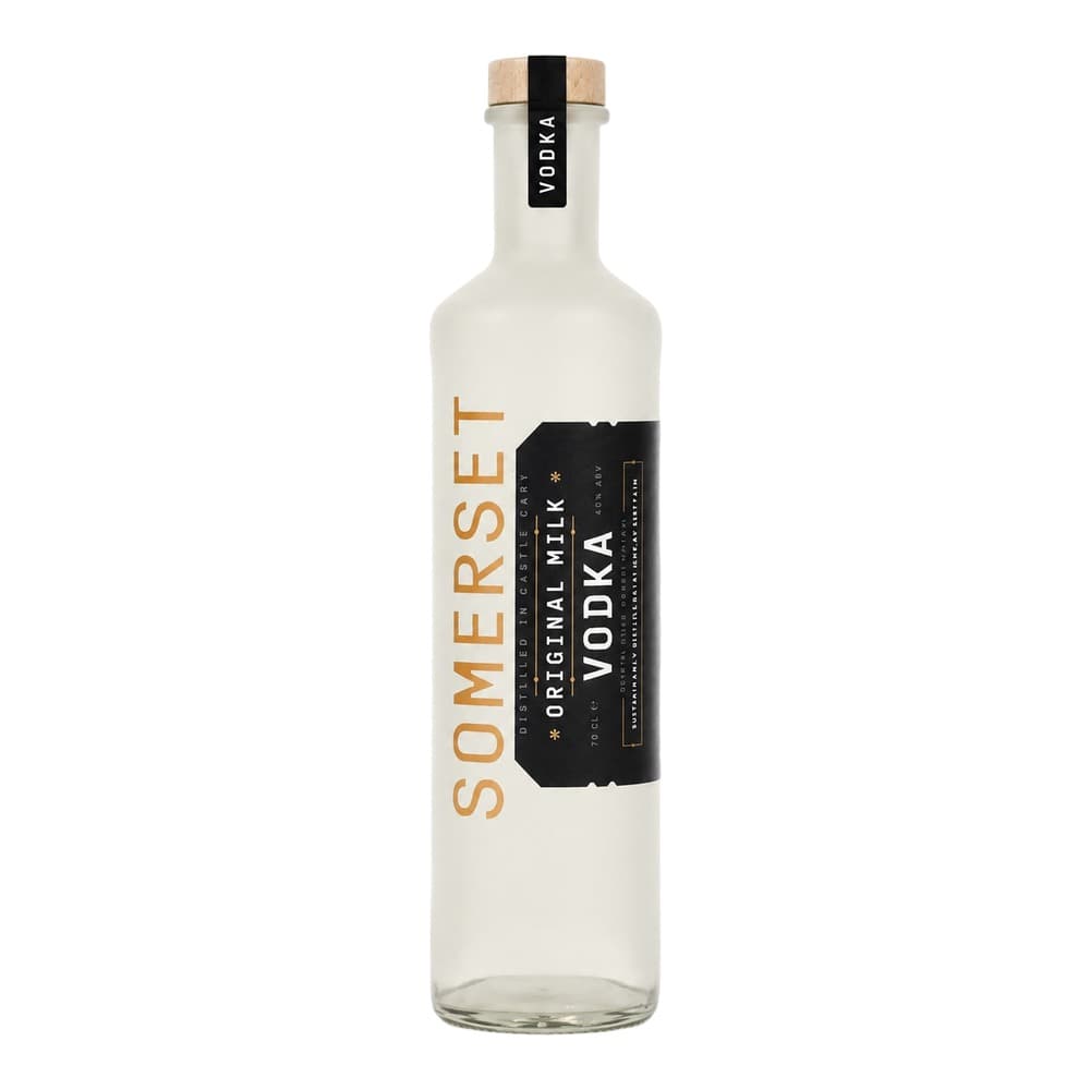 A clear glass bottle of Somersets Original Milk Vodka with a natural cork and wooden cap, featuring a cream and black label on a white background.