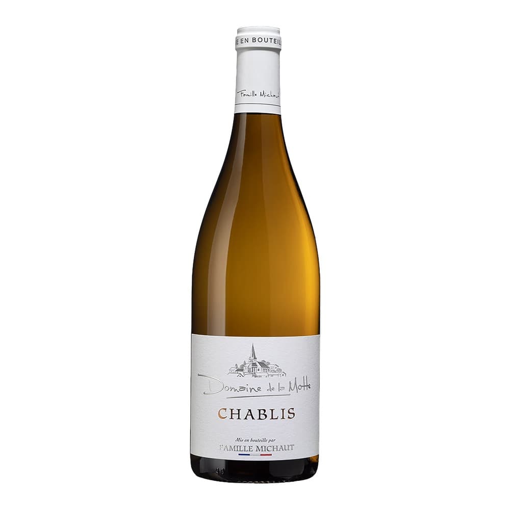A bottle of Chablis white wine from Domaine de la Motte by Famille Michaut, featuring a pale golden liquid and white label with an illustration of a church.
