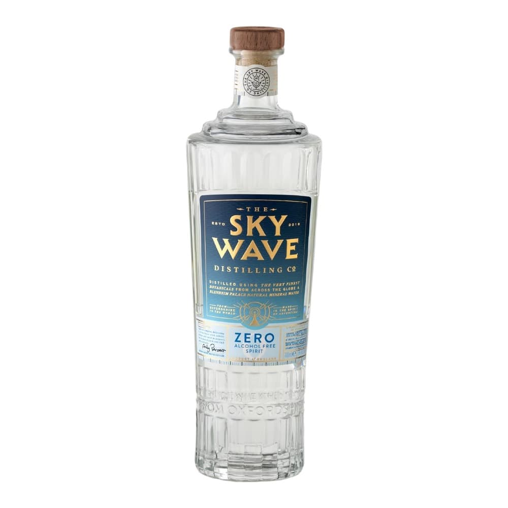 A clear glass bottle of The Sky Wave Distilling Co. zero alcohol spirit with a wooden cork closure and navy blue label, photographed against a white background.