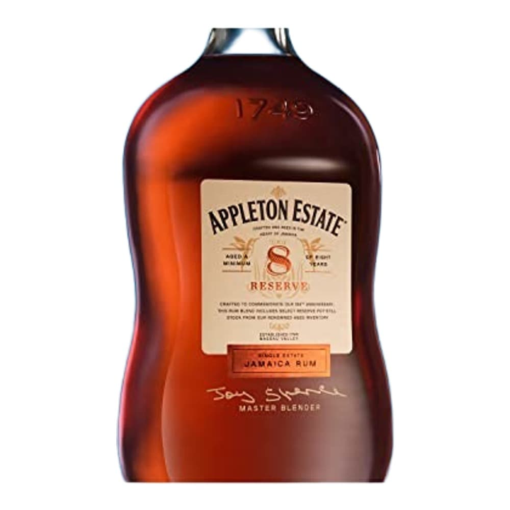A bottle of Appleton Estate Reserve Jamaica Rum against a bright blue background, displaying the cream-coloured label and dark amber liquid inside.