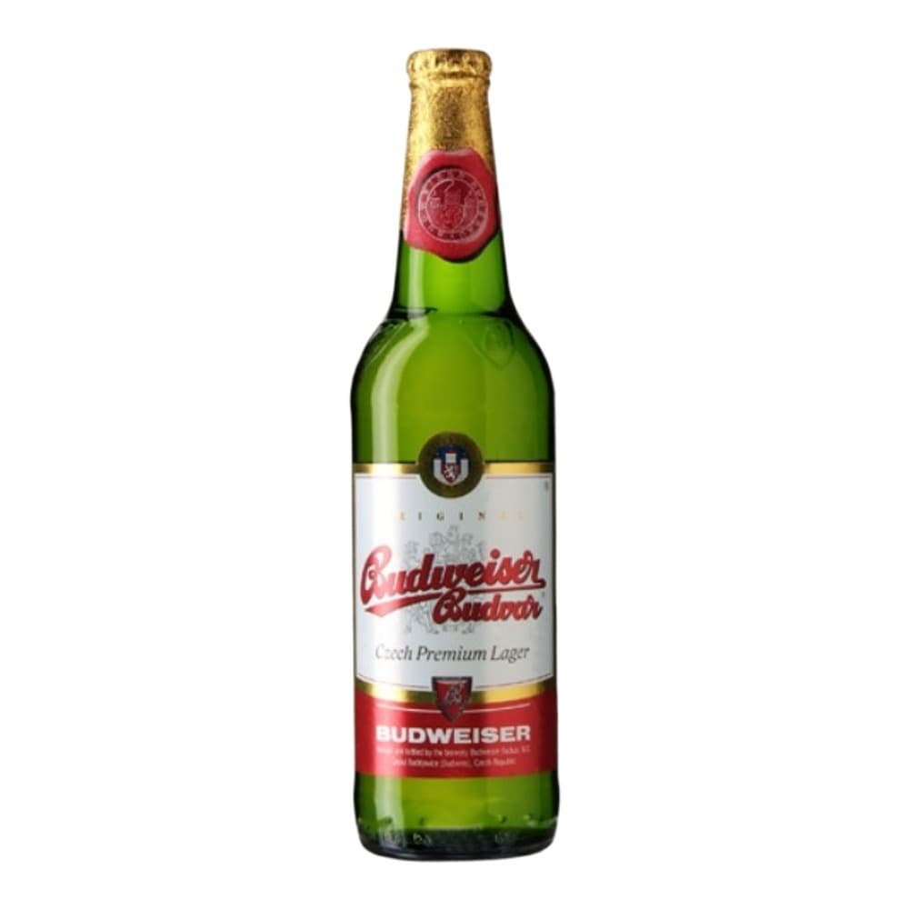 A green glass bottle of Budweiser Budvar Czech Premium Lager beer with a gold foil cap and red and white label, isolated on a white background.